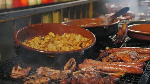 Patatas bravas, Spanish potatoes snack tapas. Traditional medieval barbecue, catalan sausages, grill BBQ medieval style, fried meat food. 