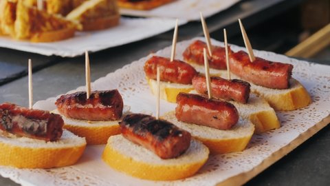 Spanish tapas, pintxos, sandwich, basque cuisine, wine snack. Traditional medieval barbecue, catalan sausages, grill BBQ medieval style, fried meat food.