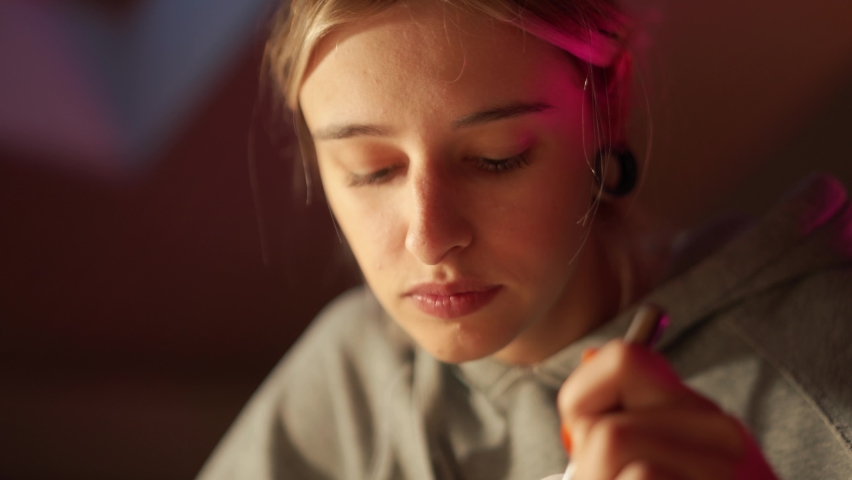 Pensive woman eating chinese food and watching film in the room at home