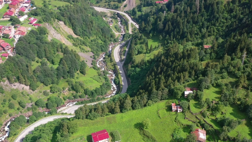 aerial top down view of a curved mountain road near a village in Uzungol Trabzon Turkey on a sunny summer day