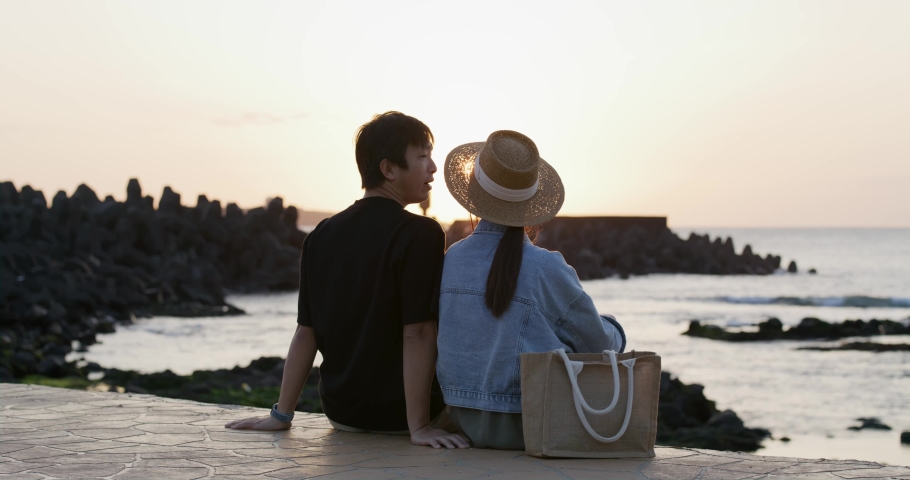 Asian couple enjoy the sunset sea view