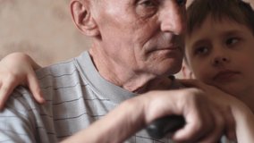 Caucasian grandson 7-8 years old hugs his grandfather over 70-80 years old holding a walking stick. Family relations between grandson and grandfather. Slow motion. grandson takes care of grandfather. - Powered by Shutterstock - Get 15% off with code: PIKWIZARD15