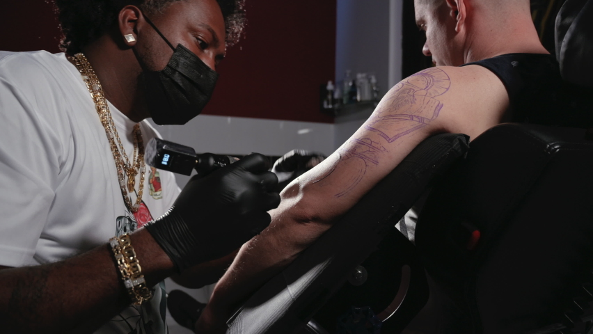 Cinematic shot of a Tattoo artist creating Body art at the tattoo studio. High quality 4k footage | Shutterstock HD Video #1090301931