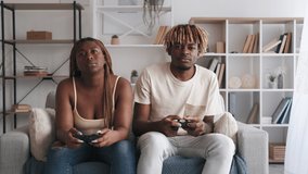 Boring video game. Annoying home leisure. Lazy weekend. Tired dissatisfied couple giving up playing losing throwing away joystick controller leaving room with modern interior.