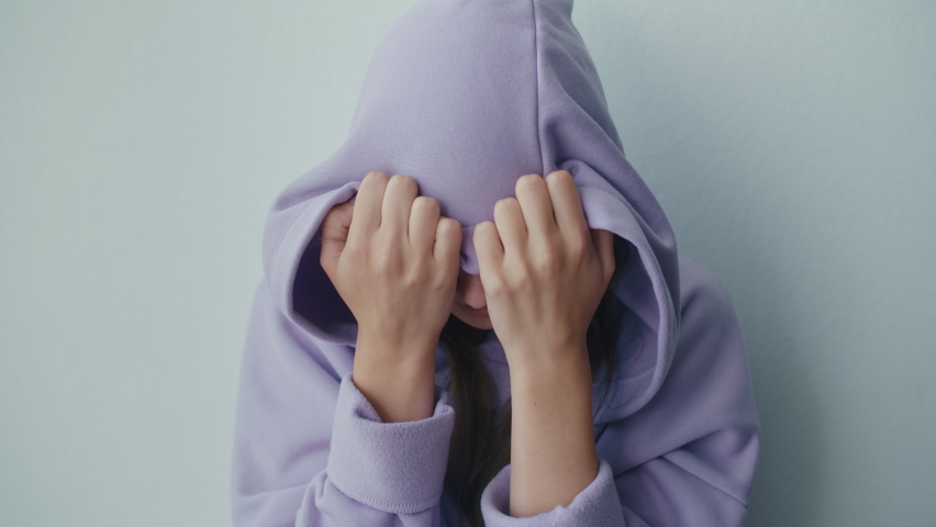 Unhappy Depressed Teenager Girl Wears Hood Sits Alone Thinking of Problem. Crying Sensitive Lonely Adolescent Teen Feeling Worried and Hurt at Home. Teenage Psychological Trauma, Complex Concept. | Shutterstock HD Video #1090307357