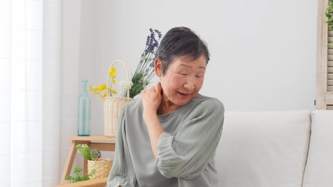 Asian senior woman having stiff shoulders at home