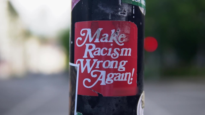 Sticker at a street lamp or pillar saying that we should make racism wrong again.