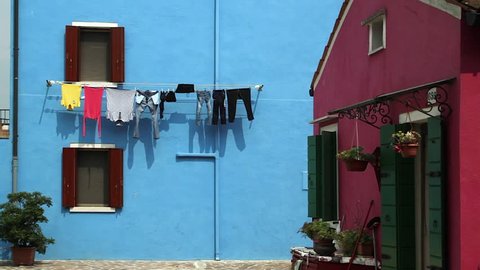 Full clothesline on the blue background wall of Burano house