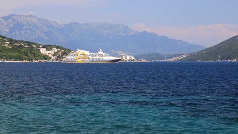 Seascape, a large white cruise liner stands in Bay of Kotor, near high mountains, Montenegro. Tourism, travel, recreation. Liner on ocean, summer vacation. Herceg Novi, Montenegro, 2021-06-17