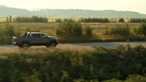 Aerial shot of off road vehicle riding on route near field. Pickup truck rides through empty asphalt road.Dodge Ram TRX.  Saint Petersburg Russia 08.06.2021