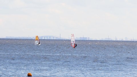 Gulf of Finland (near St. Petersburg), Russia, July 2021: Windsurfers surfing in the wind in summer. Competitions in windsurfing.