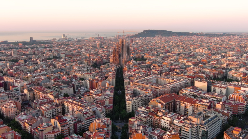 Aerial view of Barcelona Eixample residential district and famous Basilica Sagrada Familia at sunrise. Catalonia, Spain Royalty-Free Stock Footage #1090322355