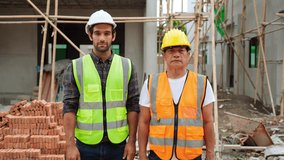 Portrait video of professional two male engineers workers crossing arms looking at camera to take photos with confident smile working together happily, Concept of teamwork in engineering working
