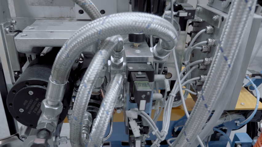 A unit of industrial equipment where the accumulation of hydraulic hoses, valves, filters and pumps ensures the operation of the mechanism. Close up. Shot in motion Royalty-Free Stock Footage #1090323737