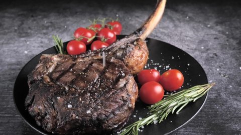 Ribeye Tomahawk Steak, Irish Beef, grilled, sprinkled with salt. High quality 4k footage