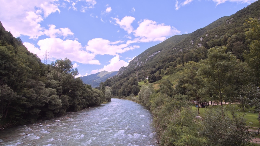 Beautiful italian mountain landscape with river in flood, slomo pan