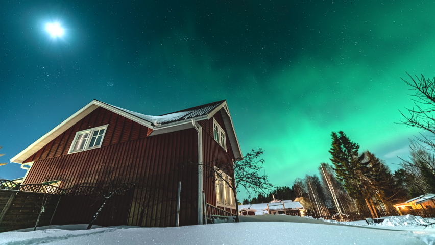 Panning time lapse video on starry night sky with mild green Aurora Borealis lights at horizon light. Traditional wooden Swedish red house with tiny clouds | Shutterstock HD Video #1090326863