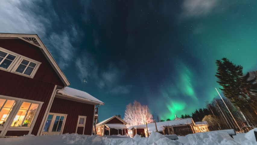 Panning time lapse video on starry night sky with mild green Aurora Borealis lights at horizon light. Traditional wooden Swedish red house with tiny clouds | Shutterstock HD Video #1090326867