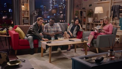 Television Sitcom Concept. Four Diverse Friends having Fun in the Living Room. TV Show Funny Sketch about Explaining Simple Thing. Comedy Series Playback on Network Channel or Streaming Service.