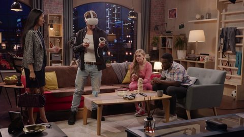 Television Sitcom Concept: Four Friends have Fun in Living Room. Funny Sketch About Two Couples. Guy in VR Headset has Metaverse Addiction. Comedy Series Broadcast Network Channel, Streaming Service