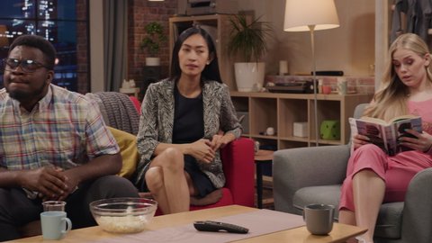 Television Sitcom Concept. Four Diverse Friends having Fun in the Living Room. Funny TV Series about Explaining Simple Thing. Comedy Show Broadcasting on Playback Channel, Streaming Service. Pan Shot