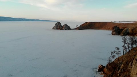Drone view of Shamanka Rock on Olkhon Island at sunset. Lake Baikal in spring. Beautiful spring landscape.