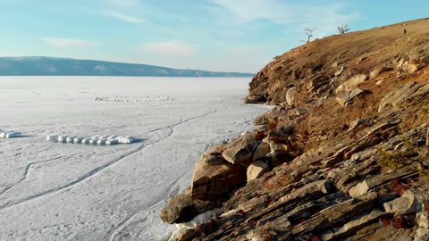 Beautiful winter landscape of Lake Baikal. Aerial view of a rocky, ice-covered island in Lake Baikal