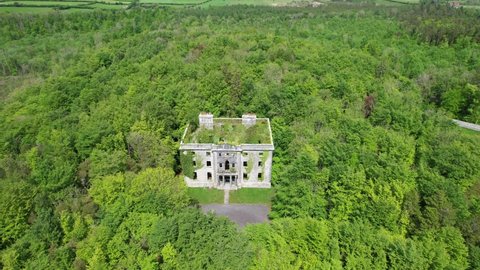 A big ruin house covered ivy and surrounded by a forest , Moore Hall is located in county Mayo Ireland and is now a public area