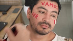 close-up painting the face of a man with the flag of Peru and the phrase 