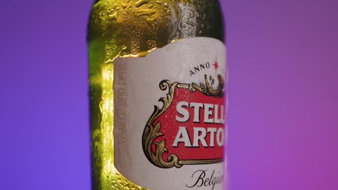 SEOULD, KOREA, SOUTH - Dec 25, 2020: A slowly rotating bottle of fresh iced Stella Artois beer on a gradient purple background