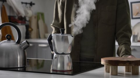 Woman make a coffee in moka pot in kitchen