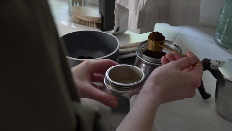 Woman make a coffee in moka pot in kitchen