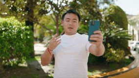 Young chinese man smiling confident having video call at park