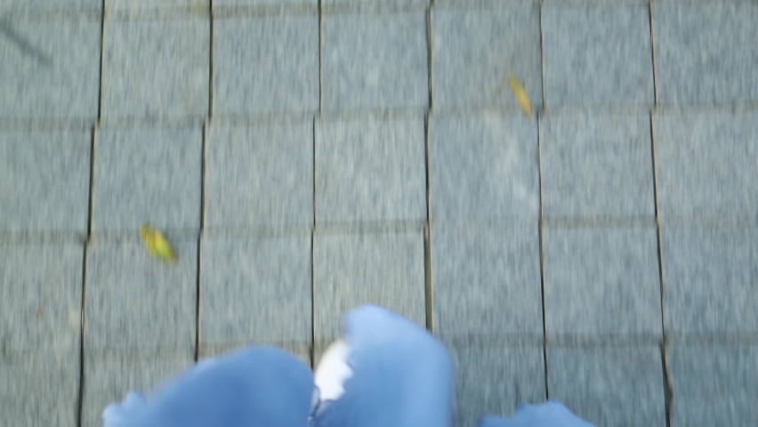 POV top view legs in white shoes sneakers under blue skirt walking on grey pavement stones tile. summer day walk concept. first person view of stepping feet. Royalty-Free Stock Footage #1090343247