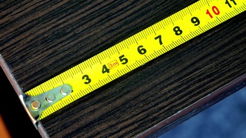 Close-up of a yellow metal measuring tape placed horizontally