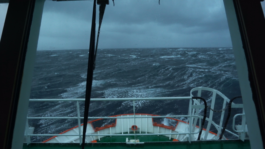 Vessel in storm. Bow breaks wave. Splashes of water. View from bridge. High waves. Strong pitching. White foam on water. Royalty-Free Stock Footage #1090345157