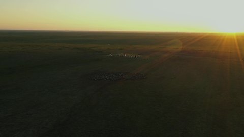 Yurts in tundra. Deer herd. Tipi. Wigwam. Peoples of Far North. Sunset. Sun in background light. Aerial view.
