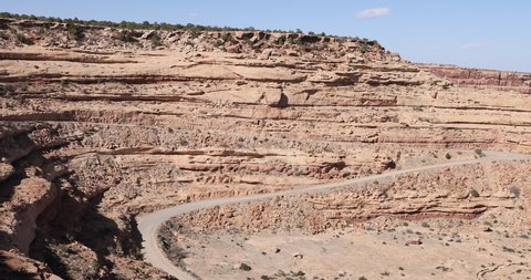 Moki Dugway steep mountain road southern Utah desert valley pan. Roadway carved from a mountain cliff. Scenic cliff Backway of Highway 261 and very narrow. Trail of the Ancients.