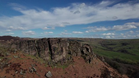 Aerial drone shot orbiting around a spectacular limestone rocky outcrop of the Roaches in the Peak District, Staffordshire, England 