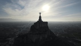 Glorious view of Christ of Monteagudo castle with glowing sun in the sky, Murcia in Spain. Aerial circling
