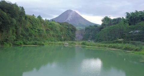 Blue lake surface with Mount Merapi in the background. Bego Pendem is the name of the place for the lava flow in Mount Merapi
