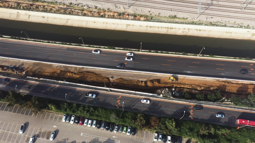 Freeway or main road with cars, traffic and parking lot from top down aerial view on a sunny day. Location is in Tel Aviv, Israel.