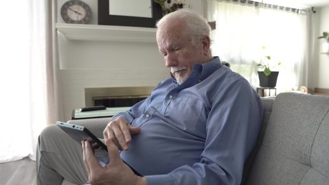 Senior Caucasian male using a tablet.