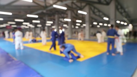 teenagers in kimono doing judo throw blurred focus