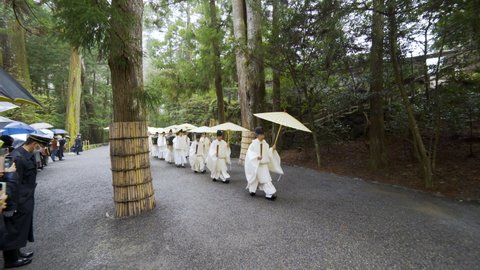 Ise Jingu, Mie Prefecture, Japan - January 11th, 2022: A row of Shinto priests march in procession in rain for an important ritual at Ise Jingu, the headquarter of all Shinto shrines in Japan