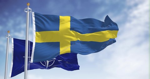 Stockholm, Sweden, May 2022: The national flag of Finland waving along with the flag of NATO. In 2022 Sweden asked to join NATO after decades of neutrality