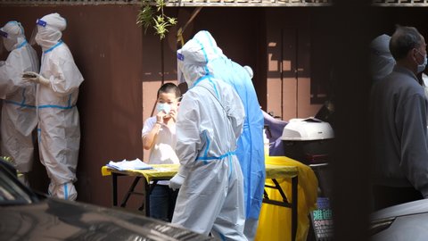 Shanghai, China May 15, 2022 People doing covid-19 test in lockdown. Health care, coronavirus and medical news concept b-roll footage. Medical worker do virus test for people in quarantined community