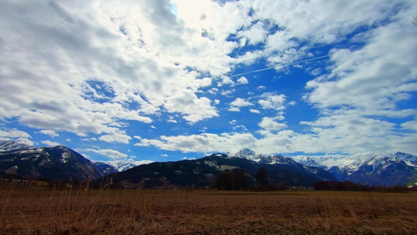 Time lapse view of clouds and planes over the marsh at Zell Am See Lake