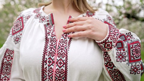 Woman demonstrates beautiful details of embroidery ornament on vyshyvanka dress. Ukrainian national costume, texture, design, folk, handmade craft needlework concept