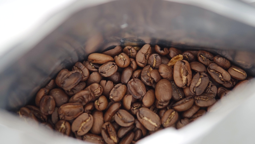 Close up of a package of fresh medium-roasted high quality coffee, arabica coffee beans. 4k footage. | Shutterstock HD Video #1090362563